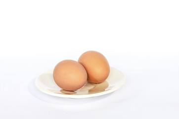 Two chicken eggs on a white plate