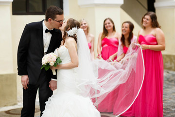 cute happy young groom and bride are kissing on the background w