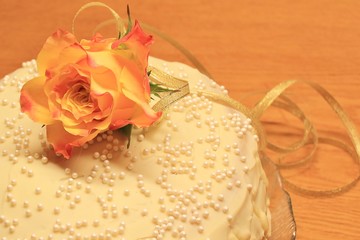 Golden wedding anniversary cake, decorated with orange rose and gold ribbon