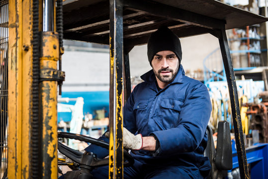 Portrait Of Male Fork Lift Truck Driver In Factory 