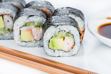 closeup roll sushi with chopsticks and ginger (shallow DOF)