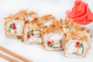 closeup roll sushi with chopsticks and ginger (shallow DOF)