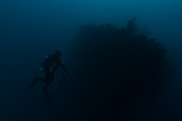 Obraz na płótnie Canvas Scuba diver exploring wreck ship in the deep.