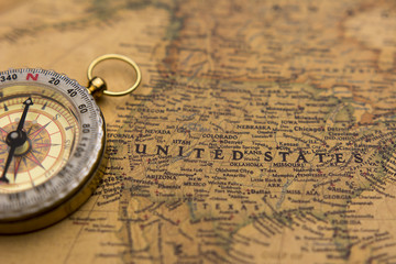 Fototapeta na wymiar Old compass on vintage map selective focus on USA