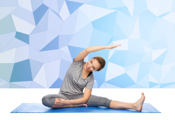 happy woman making yoga and stretching on mat