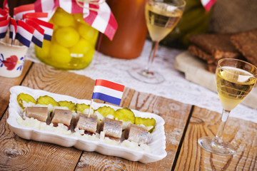 Dutch herring with onions and pickles on rustic table