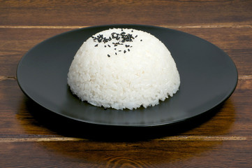 Portion of rice on the plate side view with sesame seeds