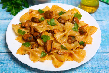 pasta with mussels and parsley on a wooden background