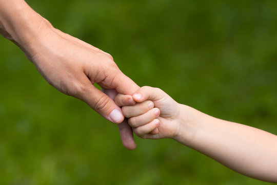 adult holding a hand of child