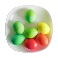 Colored Easter eggs on white plate.  Isolated with clipping path on white background. Top view.