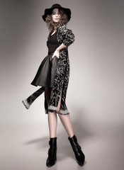 pretty woman with curly hair dressed casual posing in the studio - intentional motion light