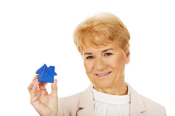 Smile elderly woman holding blue key pendant