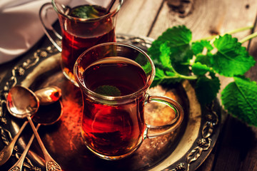 Tea with mint in the Arab style on wooden table.