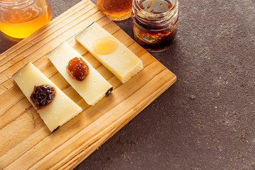 Some sliced typical Pecorino cheese with multilored jams