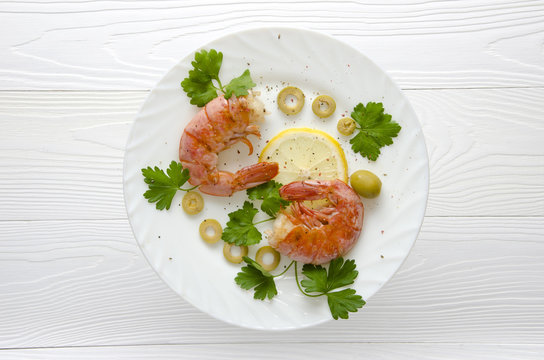 two prawns on a white plate on a white background
