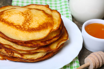 sweet pancakes with honey on wooden background 