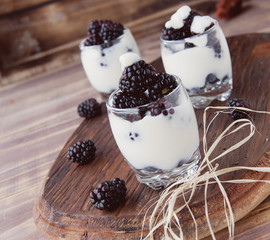 yogurt cup with blackberry on wooden table