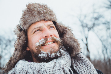 Naklejka premium Portrait of a young handsome man with a beard. Bearded man in winter. 