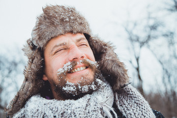 Naklejka premium Portrait of a young handsome man with a beard. Bearded man in winter. 