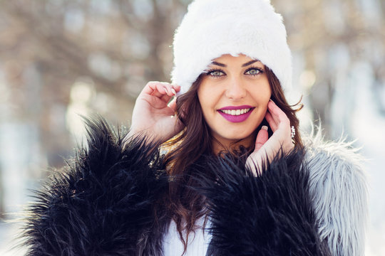 Young woman in fur coat and hat winter portrait