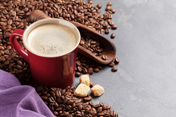 Coffee cup, beans and brown sugar on stone table