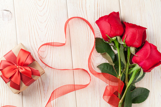 Red roses, gift box and heart shaped ribbon