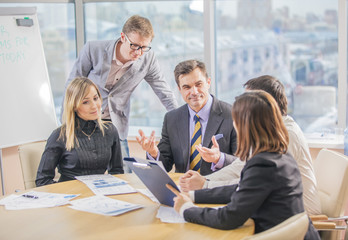 Group of successful business partners in casual communicating at meeting in office