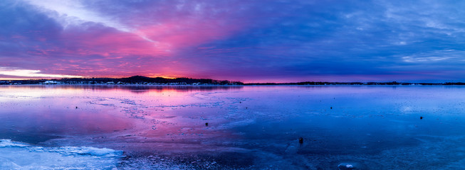 Panorama Colorful Sunrise over frozen lake.