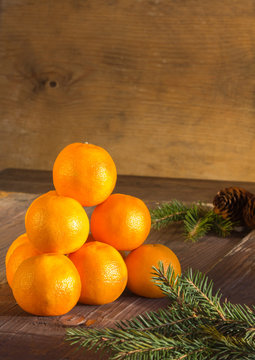Tangerines and fir branches on old dark wooden background. Christmas New Year composition