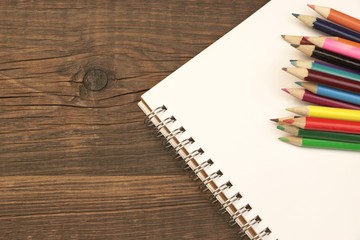 Opened Spiral Notepad With Blank Page And Many Color Pencils