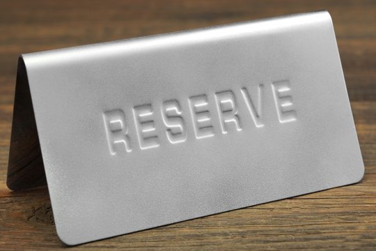 Metal Sign Reserve On The Restaurant Wood Table Background