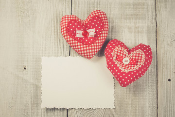 Two hearts hanging on wooden background
