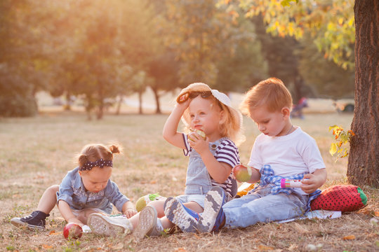 Stylish Toddlers Eating An Apples During Picnic