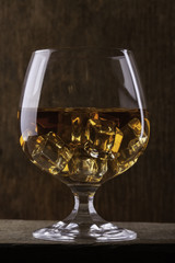glass of cognac with ice closeup  on cloth background