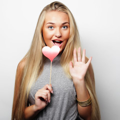  Playful young woman holding a party heart.