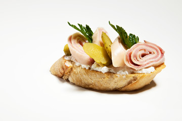 Sandwich with white cheese, ham,cucumber and parsley on the whit