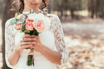 bride holding wedding bouquet with roses and other flowers - 101070147