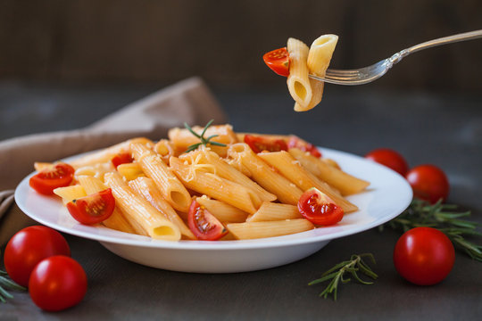 Pasta in tomato sauce on a wooden table
