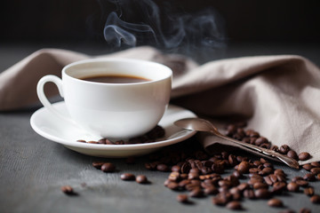 Coffee cup and saucer on a wooden table. Grey background
