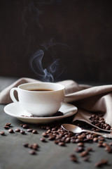 Coffee cup and saucer on a wooden table. Grey background