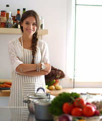 Young woman standing near desk in the kitchen