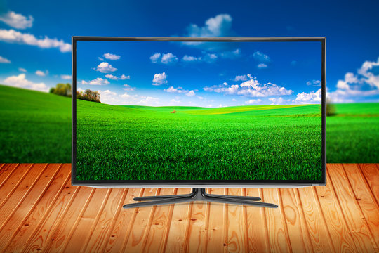 television on a wooden table on a background nature