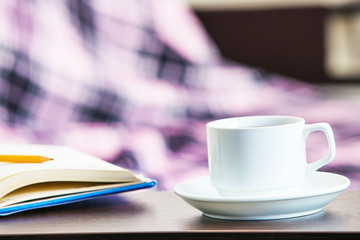 notebook with coffee isolated on a wooden background