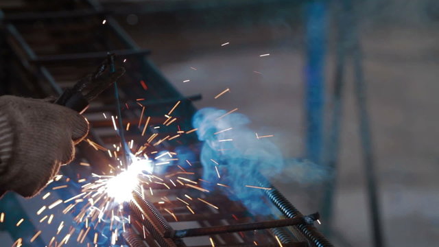 Man welding metal grid