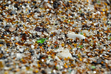 Close-up shot of sand on Glass Beach in Hanapepe, Kauai, Hawaii. The beach is located in an industrial area where glass was dumped for many years and is now visible as sea glass. 