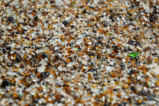 Close-up shot of sand on Glass Beach in Hanapepe, Kauai, Hawaii. The beach is located in an industrial area where glass was dumped for many years and is now visible as sea glass. 