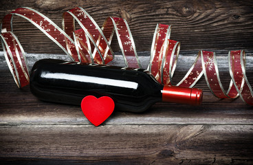 Red Wooden Heart, Bottle Of Red Wine And Beautiful Ribbon On Old Wooden Boards. Romantic Composition.