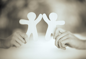 Hands with wooden mens on green nature background.  Retro style. Friendship, ecology or teamwork concept