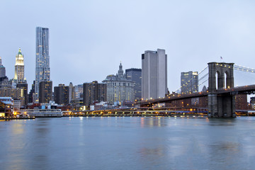 Fototapeta na wymiar New York City Brooklyn Bridge and Manhattan skyline with skyscrapers over Hudson River at dusk after sunset.