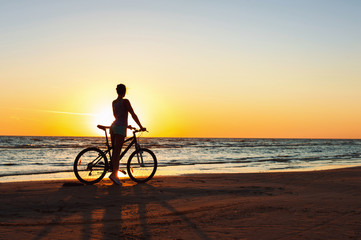 Obraz premium Catching a moment in time. Sporty woman cyclist at sunset backgr